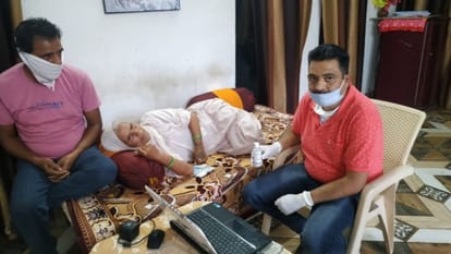 माइक्रो एटीएम की मदद से बुजुर्गों को घर बैठे पेंशन देते बैंक कर्मचारी